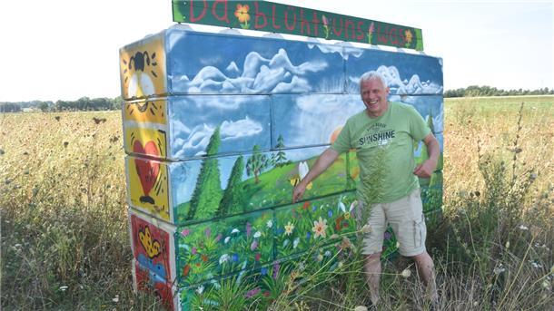 Diese bunte Mauer vor einem Blühfeld in Wistedt hat Sebastian Müller, ein ehemaliger Mitarbeiter von Andreas Pape, gestaltet. Sie weist auf das von den Landwirten initiierte Projekt „Da blüht uns was" hin .