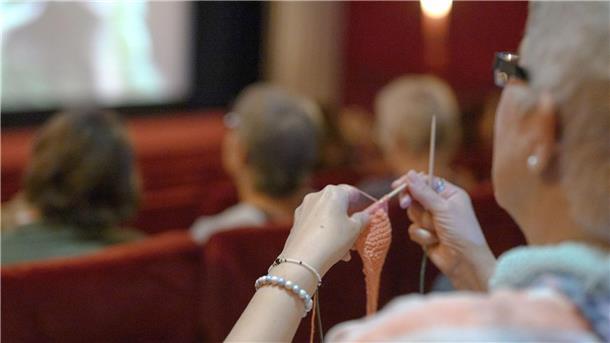 Stricken und gucken Diese Frau hat ihr Strickzeug mit ins Kino gebracht.