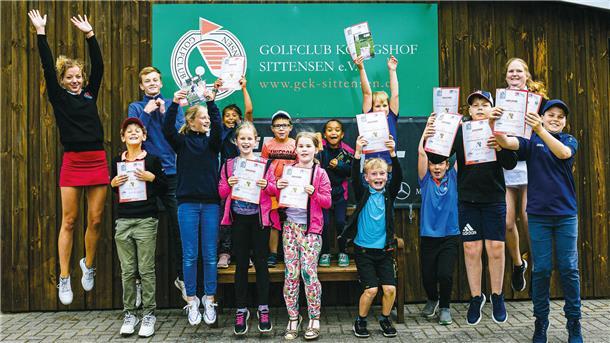 Eine Gruppe freut sich über das Kindergolfabzeichen. 