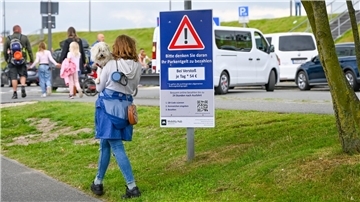 Frau schaut auf das Hinweisschild am Neuen Hafen