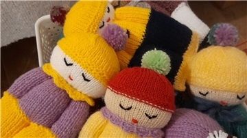 Gestrickte Sorgenpuppen in einem Korb.