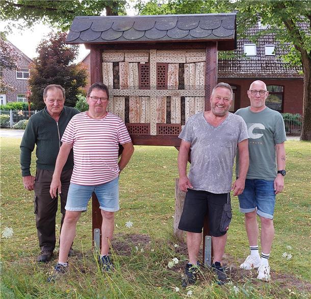 Vier Männer vor einem großen Insektenhotel 