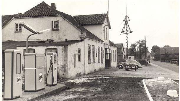 Dieses Bild zeigt noch den alten „Kaiserhof“, vor dem gerade ein Pfingstbaum aufgestellt wurde. Links vom Gebäude gab es eine Tankstelle.