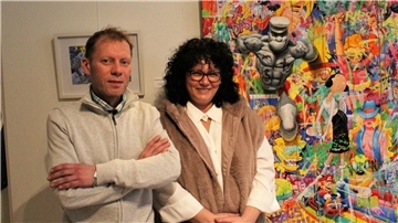 Künstler Dimitri Wall mit Kuratorin Nadine Eskorbier vor einem farbenfrohen Gemälde in der Ausstellung der Galerie HermyM