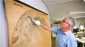 Dr. Christian Salewski zeigt ein kleines Messgerät, mit dem Alfred Wegener und seine Gefährten bei ihrer Grönland-Expedition in den 1930er Jahren Wetteerdaten gesammelt haben.