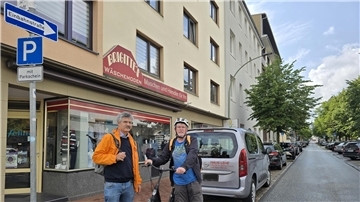 Zwei Männer mit einem Fahrrad an der Einfahrt zu einer Einbahnstraße