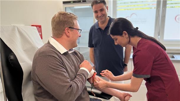 Dr. Niazi Habash (hinten stehend) betreibt jetzt in Schiffdorf eine Hausarztpraxis. Zur Eröffnung kam auch Bürgermeister Henrik Wärner (sitzend). Er ließ sich im Rahmen eines Gesundheitschecks „piken“.