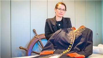 Dr. Tanja Fittkau, Wissenschaftliche Mitarbeiterin am Deutschen Auswandererhaus, zuständig für die Museumssammlung, die 3000 Familienkonvolute mit rund 29.000 Objekten umfasst, mit einer historischen Gala-Uniform von Kurt Koswig aus dem Jahr 1910.