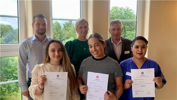 Drei der vier neuen anerkannten Pflegefachkräfte freuen sich über ihre Urkunden (vorne, von links): Ornela Bejdo, Cinthya Gonzalez Gonzalez und Judith Yazmin Hernandes Lopez. Gratuliert haben (hinten, von links): Praxisanleiter Alexander Famulla, Integrationsmanagerin Johanna Chrapek und Pflegedirektor Jörg Schulte.