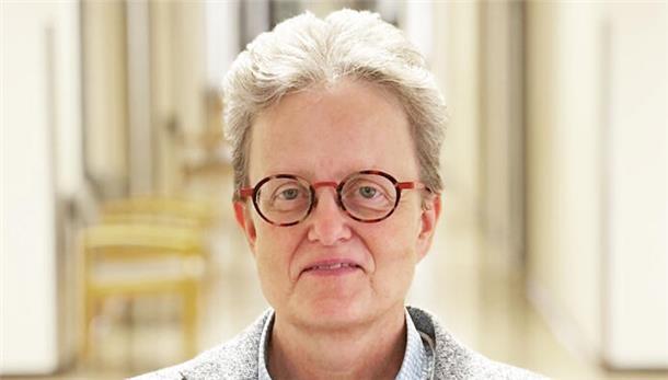 Eine Frau mit Brille blickt in die Kamera.