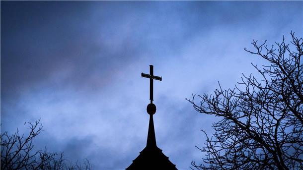 Haft für Pfarrer auf Sizilien wegen Missbrauchs Dunkle Wolken über einem Kreuz einer Kirche: Einem der Opfer muss dSchadenersatz gezahlt werden (Symbolbild).