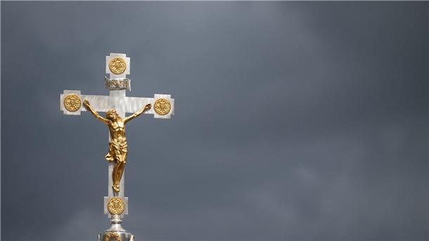 Mehr als halbe Million Katholiken aus Kirche ausgetreten Dunkle Wolken über einem Kruzifix: Immer mehr Menschen nehmen Abstand von der Katholischen Kirche.