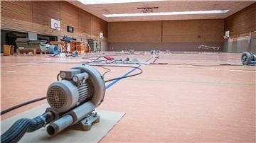 Durch den Grundwassereintritt muss seit rund drei Wochen der Boden der großen Sporthalle des OSC mit Elektrolüftern getrocknet werden. Foto: Hartmann