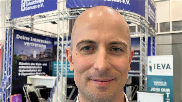 Dustin Dahlmann, Vorsitzender des E-Zigaretten-Verbandes „Bündnis für Tabakfreien Genuss“ (BfTG), steht bei der Messe Intertabac 2023 vor einem Stand seiner Organisation.