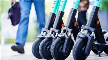 E-Scooter des Elektro-Tretroller-Sharing-Anbieters „Tier Mobility“ stehen am Rand eines Bürgersteigs.
