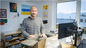 Ecocool-Geschäftsführer Dr. Florian Siedenburg zeigt einen 15-Liter-Karton, der mit Vlies ausgelegt wird. Das Vlies ist aus alten Plastikflaschen hergestellt worden.