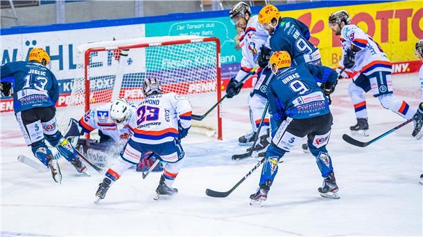 Spieler zweier Eishockey-Mannschaften auf dem Spielfeld.