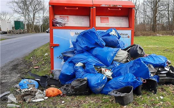 Wieder Stellplatz komplett verdreckt: Wilde Mülldeponie in Ellwürden Mehrere Tüten mit Müll liegen vor zwei Altkleidercontainern.
