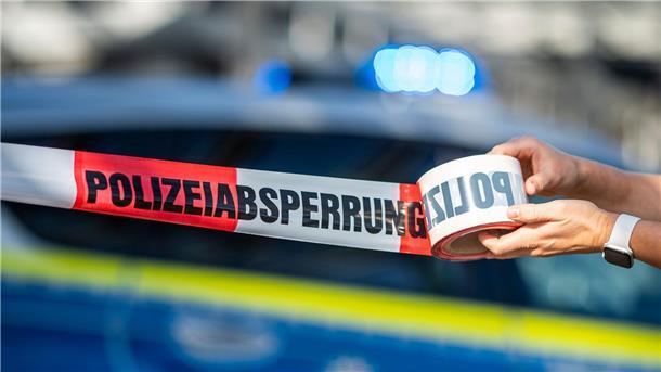 Wohnmobil für Prostitution brennt ab  Ein Absperrband wird vor einem Polizeiwagen ausgerollt.