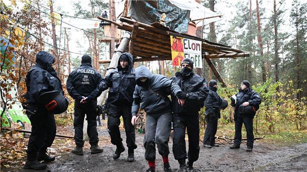 Zähe Hängepartie - Polizei löst Tesla-Protestcamp auf Ein Aktivist wird von Polizisten aus dem Protestcamp in der Nähe des Tesla-Autowerks in Grünheide abgeführt.