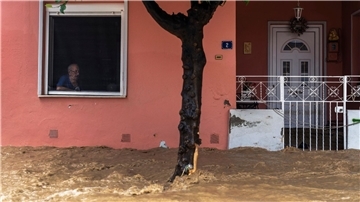 Ein Anwohner blickt aus dem Fenster seines Hauses auf die überschwemmte Straße.