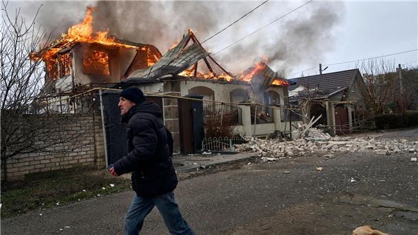 Selenskyj erklärt Waffenruhe für gescheitert Ein Anwohner läuft an einem brennenden Haus in Cherson vorbei, das nach ukrainischen Angaben bei russischem Beschuss am orthodoxen Weihnachtsabend getroffen wurde.