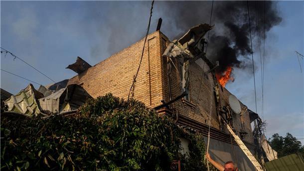 Krieg gegen die Ukraine: So ist die Lage Ein Anwohner löscht ein Feuer in einem Haus, das nach russischem Beschuss in Cherson, Ukraine, beschädigt wurde.