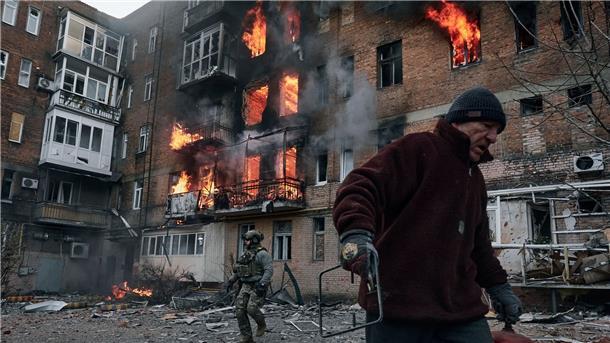 Ein Anwohner verlässt in Bachmut sein Wohnhaus, das nach einem Beschuss in Flammen steht.