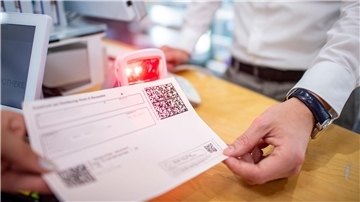 Ein Apotheker scannt den QR-Code eines E-Rezepts ein.