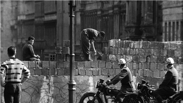 Ein Arbeiter erhöht die Sektorensperre an der Bernauer Straße in Berlin im August 1961. Fast Abend für Abend war es an diesem und anderen Mauerabschnitten zu Zwischenfällen gekommen. 