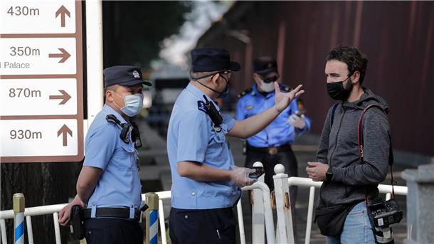 Ausländische Reporter beklagen Arbeitsbedingungen in China Ein ausländischer Journalist wird in Peking von Polizisten angehalten und befragt, nachdem er versucht hatte, die Busse von Delegierten des chinesischen Volkskongresses zu fotografieren (Archivbild).