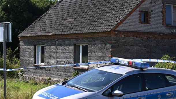 Ein Auto der Polizei steht während Ermittlungsarbeiten vor einem Familienhaus.