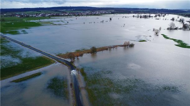 Scholz erneut im Hochwassergebiet: Kritik von Anwohnern Ein Auto fährt am Rande des aufgestauten Rückhaltebeckens der Ohm. In Hessen ist noch keine Entspannung beim Hochwasser in Sicht.
