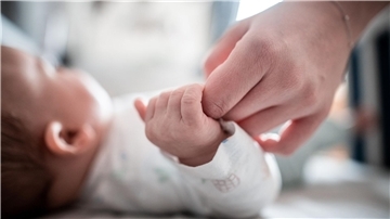 Ein Baby klammert sich an den Finger seiner Mutter. In Italien kommen immer weniger Babys zur Welt.