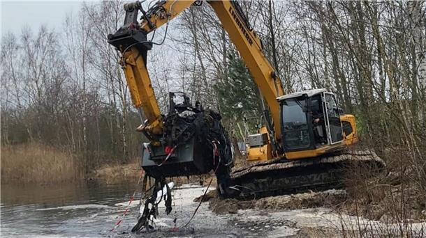 Polizei untersucht Autogerippe an der Lunestedter Baggerkuhle Ein Bagger hebt die Überreste des Autos aus der Baggerkuhle.
