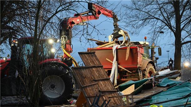 Abrissbagger in Lützerath - Widerstand bröckelt Ein Bagger lädt in Lützerath Reste von Hütten auf einen Lkw.