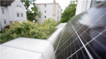 Ein Balkonkraftwerk hängt an einem Balkon. Die Nachfrage nach der eigenen Solaranlage auf dem Dach ist in Deutschland sprunghaft gestiegen.