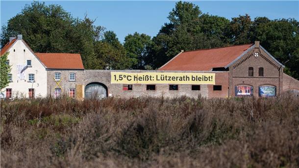 Schnellerer Kohleausstieg im Westen Ein Banner mit der Aufschrift „1,5 Grad heißt: Lützerath bleibt!“ an einem alten Hof in Lützerath. Doch nun soll das Dorf weichen.