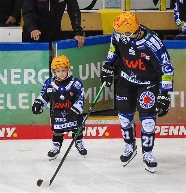 Ein Eishockeyspieler und ein kleiner Junge