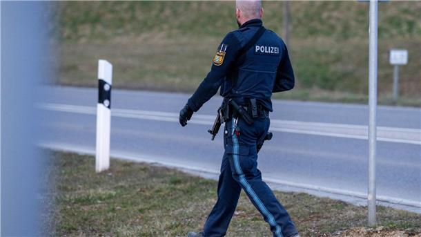 Ein bewaffneter Polizist geht auf einer Straße am Ortsrand von Parsberg.
