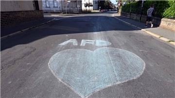 Ein blaues Herz und der Schriftzug AfD sind mit Kreide auf eine Straße in Sonneberg gemalt.