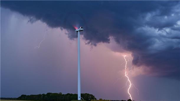 Gewitter in Deutschland - Bahnverkehr in Erfurt gestoppt Ein Blitz leuchtet am Abendhimmel hinter einer Windenergieanlage im Osten Brandenburgs.