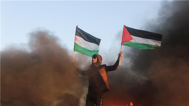 Nach Raketenangriff: Israel greift Ziele im Gazastreifen an Ein Demonstrant in Gaza mit palästinensischen Fahnen (Archivbild).