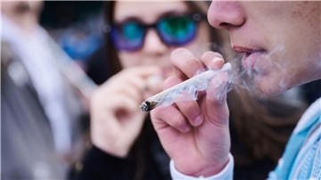 Ein Demonstrant mit einem Joint während einer Demonstration in Berlin für die Freigabe von Cannabis.