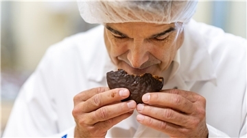 Ein Fachmann prüft, ob die frisch gebackenen Lebkuchen auch schmecken.