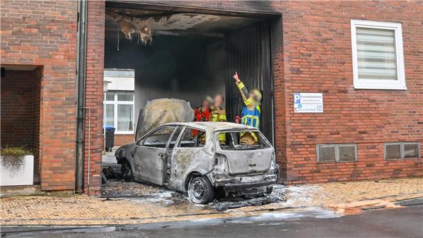 Auto brennt mitten in der Bremerhavener Innenstadt: Video zeigt Ausmaß des Feuers Ein brennendes Auto steht an einem Gebäude.