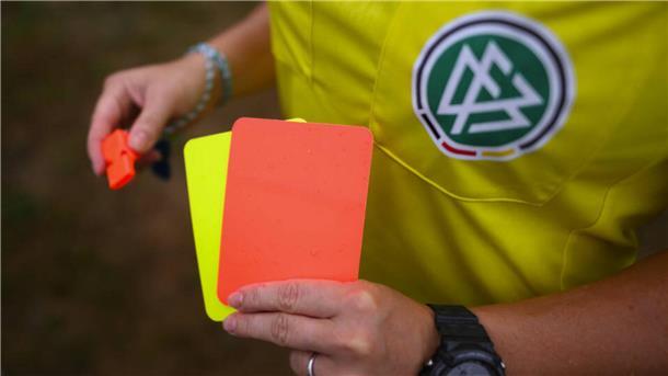 Sonne, Sport und Männerbild: die psychologische Kraft der Farbe Gelb Ein DFB-Schiedsrichter hält eine Rote und eine Gelbe Karte in der Hand.