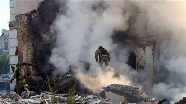 Krieg gegen die Ukraine: So ist die Lage Ein Feuerwehrmann geht durch den Qualm eines brennenden Hauses in Charkiw.