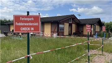 Ein Teil einer Ferienhaussiedlung ist mit Flatterband abgesperrt.