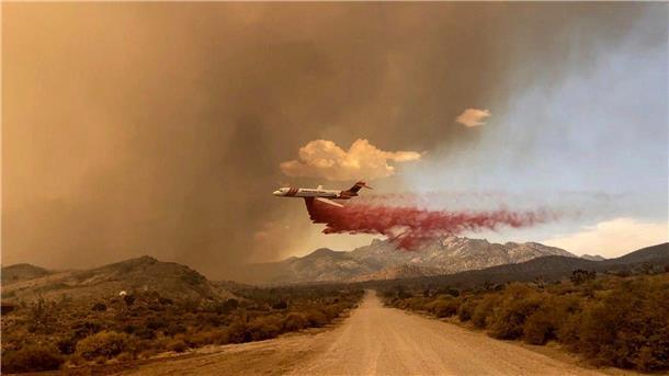 Feuer in kalifornischer Mojave-Wüste Ein Flugzeug wirft Löschmittel über der kalifornischen Mojave-Wüste ab.